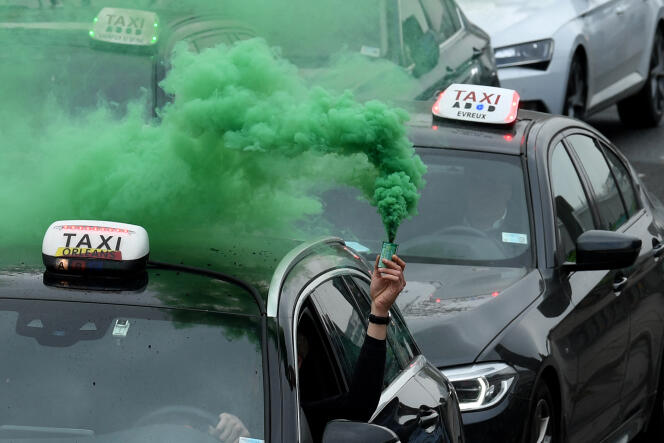 Des dizaines de taxis protestent contre la hausse des prix des carburants alors qu’ils se rendent de l’aéroport international de Roissy - Charles-de-Gaulle à Bercy, à Paris, le 30 mars 2022.
