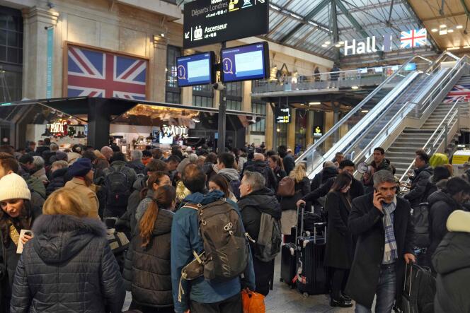 Passengers wait at the bottom of a staircase leading to the Eurostar platform at Gare du Nord in Paris on December 21, 2023, as a strike by Channel Tunnel workers blocks train services between France and Great Britain.