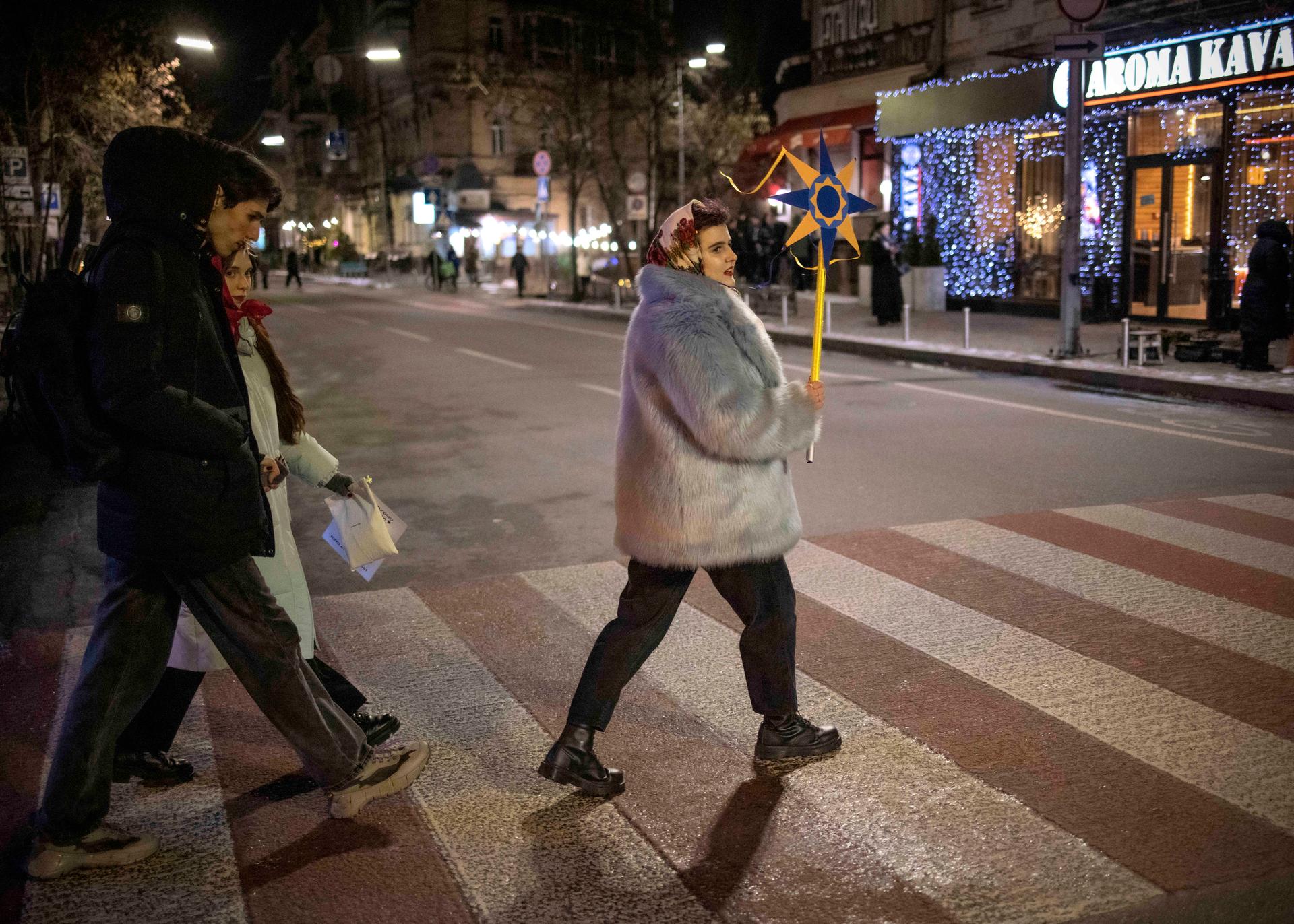 Hanneh, a 26-year-old humanitarian volunteer, holds a handmade Christmas star in downtown Kyiv on December 24, 2023. This is the first time she and her friends have organized a koliadka (Christmas choir). "Before the Russian invasion, koliadkas weren't very fashionable, but today it's become cool, you could say that nowadays traditions are part of pop culture," she explained.