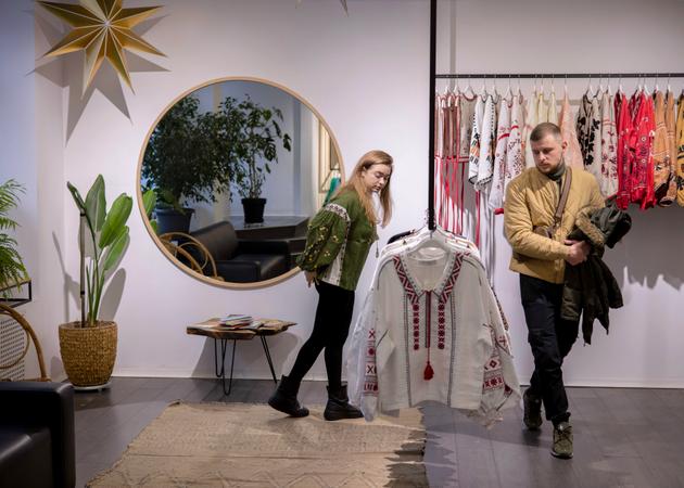 A Ukrainian couple chooses a "vyshyvanka" – a traditional Ukrainian shirt that literally means "embroidery" – before Christmas at the trendy Etnodim store in Kyiv on December 23, 2023. These shirts are worn on religious holidays and other festive occasions.