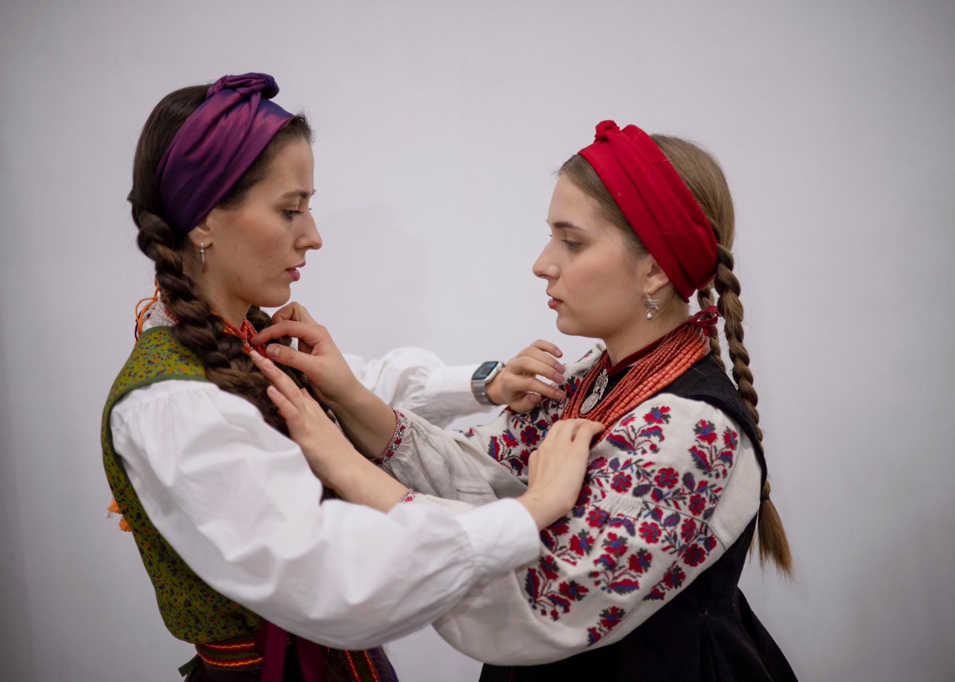 July Vitraniuk (right), 23, and her friend get ready for a concert in Kyiv on December 24, 2023. Vitraniuk began singing at the age of 6. Today she specializes in traditional Ukrainian singing. "I could dress like this every day, but it would still be strange," she said.