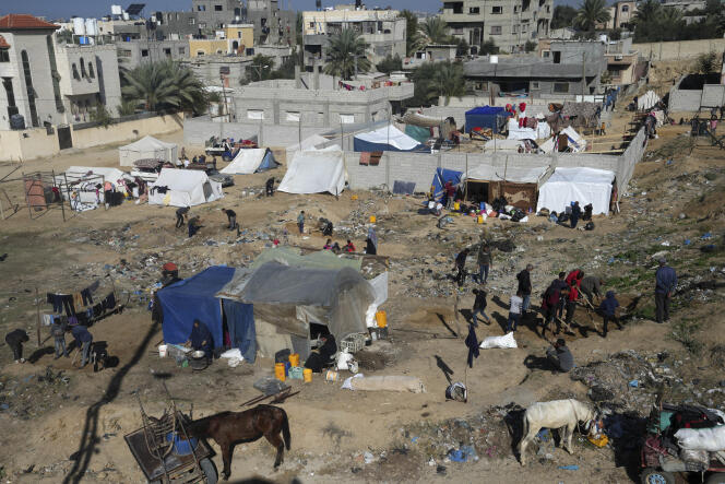 Des Palestiniens, déplacés en raison de la guerre entre Israël et le Hamas, installent des tentes de fortunes à Deir Al-Balah, dans le centre de la bande de Gaza, le 26 décembre 2023.