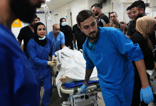 Los médicos llevan a un periodista herido por fuego israelí en la aldea fronteriza de Alma El-Chaab al hospital en la ciudad portuaria de Tiro, en el sur del Líbano, el viernes 13 de octubre de 2023.