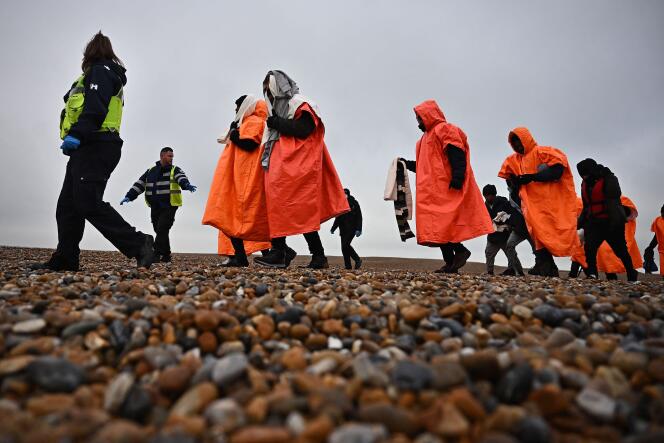 Des migrants, recueillis en mer alors qu’ils tentaient de traverser la Manche, sont escortés sur le rivage de Dungeness, sur la côte sud-est de l’Angleterre, le 9 décembre 2022.