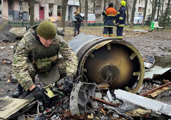 Un démineur travaille à côté d’une partie d’un rocket  russe sur le tract  où des immeubles résidentiels ont été lourdement endommagés dans le centre de Kharkiv, en Ukraine, le 2 janvier 2024.