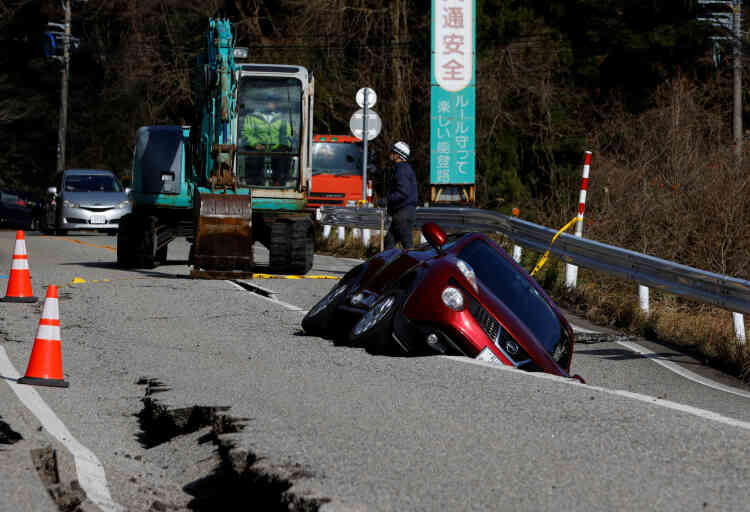 Una vista di un'auto bloccata in una crepa stradale vicino a Ojima, prefettura di Ishikawa, Giappone, 2 gennaio 2024.