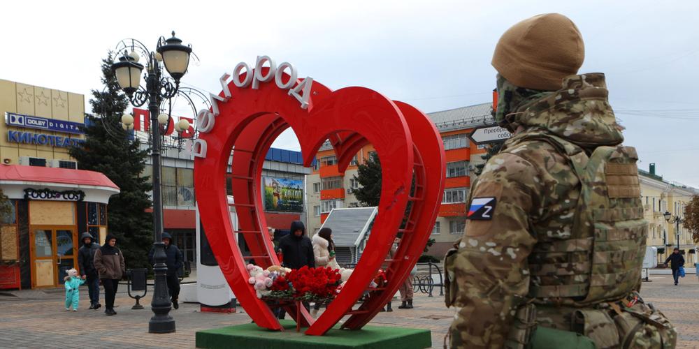 Un militaire russe monte la garde près d’un mémorial de luck  dédié aux victimes des tirs d’obus qui, selon les autorités russes, ont été perpétrés par les forces armées ukrainiennes, à Belgorod, Russie, le 31 décembre 2023.