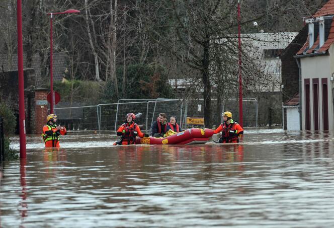 Los bomberos evacuan a los residentes utilizando un bote inflable de una calle inundada en Arques, al norte de Francia, debido a la inundación del Aa.
