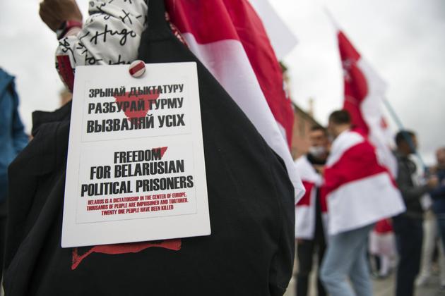 In Poland, a Belarusian exile holds a placard calling for "freedom for Belarusian political prisoners", during a demonstration in Warsaw, August 9, 2023.