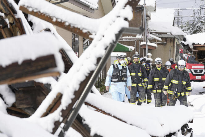 Los bomberos buscan, bajo la nieve, casas que se derrumbaron en la ciudad japonesa de Suzu durante el terremoto de Año Nuevo, el lunes 8 de enero de 2024. 