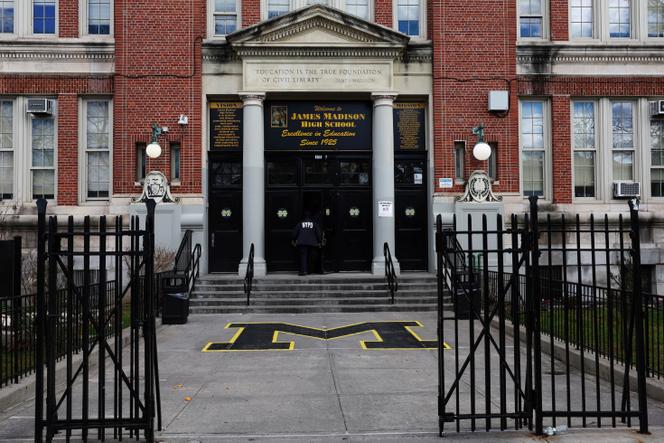 Des policiers à la porte du lycée James-Madison, où les migrants du centre d’hébergement Floyd Bennett Field ont été temporairement déplacés jusqu’au passage d’une tempête hivernale, à Brooklyn (Etat de New York), le 10 janvier 2024.  