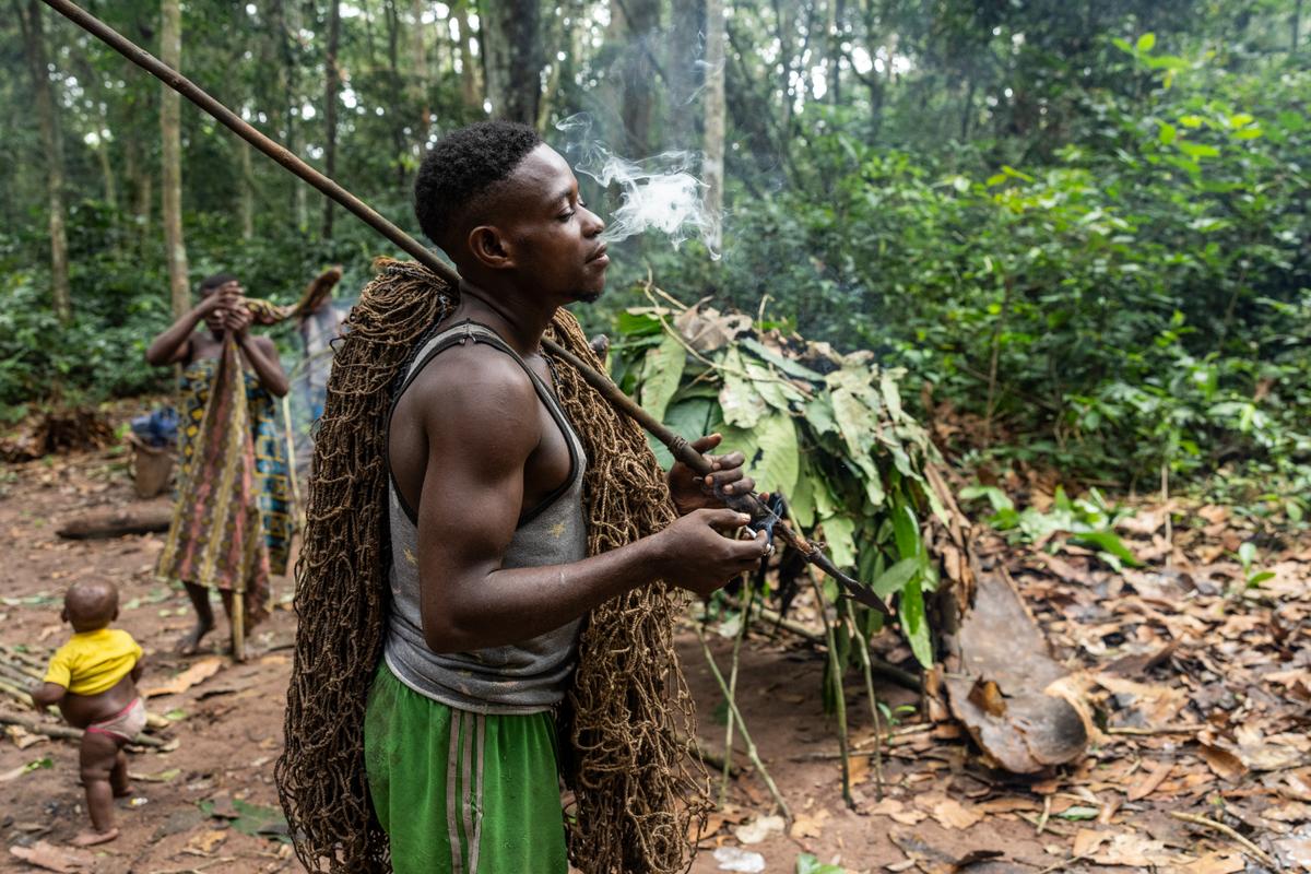 Modebe Bosco, a member of a Bayaka community, smokes cannabis before going hunting in the buffer zone of Dzanga-Sangha National Park, Central African Republic.