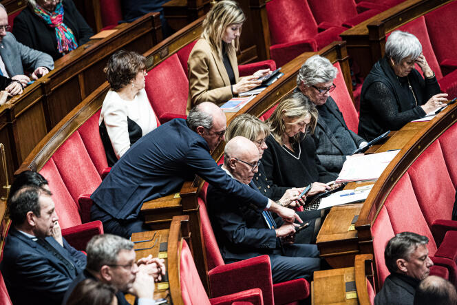 Le président du groupe LR, Olivier Marleix, pointe en direction du téléphone du député LR, Eric Ciotti, lors de la séance de questions au gouvernement à l’Assemblée nationale, le 16 janvier 2024.