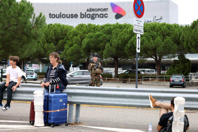 Des voyageurs attendent à l’extérieur de l’aéroport de Toulouse-Blagnac, dans le sud-ouest de la France, le 18 octobre 2023, après l’évacuation des lieux en raison d’une alerte à la bombe. 
