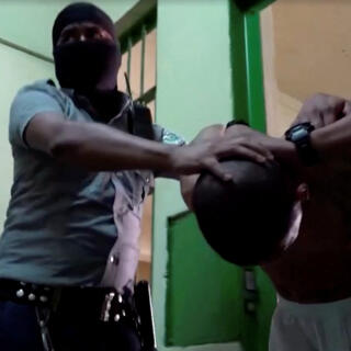 A prisoner is being held as police officers inspect cells and inmates belongings, as El Salvador conducts exhaustive prison raids as part of territorial control plan, in El Salvador, January 10, 2024, in this screen grab taken from a handout video. El Salvador Presidency  /Handout via REUTERS    THIS IMAGE HAS BEEN SUPPLIED BY A THIRD PARTY