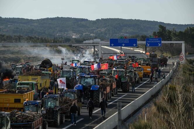 Des agriculteurs protestent avec des tracteurs pour bloquer l’autoroute A9, près du péage de Narbonne Sud, le 26 janvier.