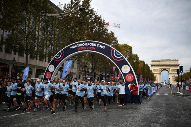 Los corredores toman la salida de una carrera de 5 kilómetros a lo largo de los Campos Elíseos, durante la J-1000 París 2024 – Maratón para todos, en París, el 31 de octubre de 2021. 