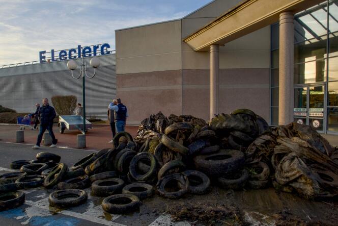 Des pneus sont déposés par des agriculteurs à l’entrée d’un supermarché E.Leclerc au Mans, dans le nord-ouest de la France, le 26 janvier 2024.