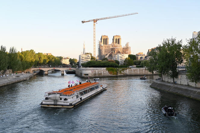 Un bateau péniche navigue vers la cathédrale Notre Dame de Paris sur la Seine, le 17 juillet 2023, lors d’une parade de test de la future cérémonie d’ouverture des Jeux olympiques de Paris en 2024.