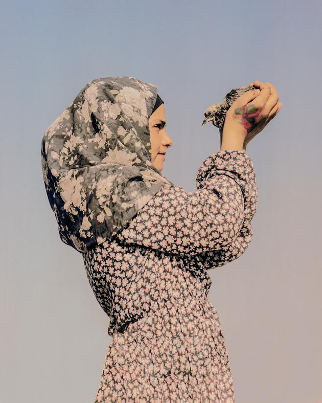 Hanin, a young Bedouin from the village of Nu'eima, north of Jericho, with her pet pigeon, March 5, 2023.