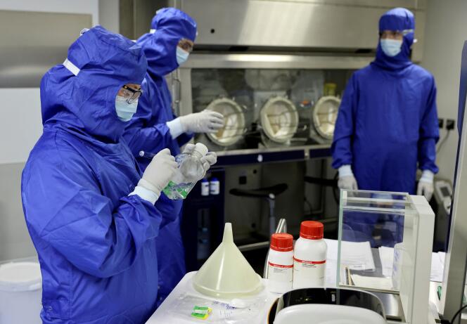 Des techniciens de laboratoire travaillent sur une machine de traitement pour produire des cellules CAR-T et de l’ARN, dans le laboratoire de la société biopharmaceutique Cellectis, à Paris, le 23 septembre 2021. 