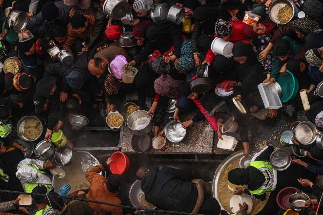 Des Palestiniens reçoivent des rations alimentaires dans un camp de déplacés à Rafah, dans le sud de la bande de Gaza, le 2 février 2024, alors que les combats se poursuivent entre Israël et le groupe palestinien Hamas. 