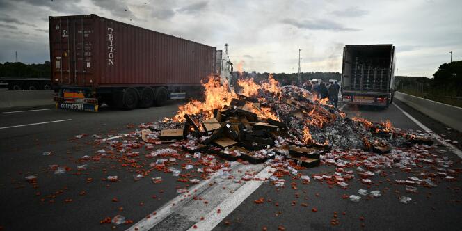 Des caisses de tomates brûlent sur l’autoroute au péage du Boulou, près de la frontière espagnole, dans le sud de la France, le 19 octobre 2023.