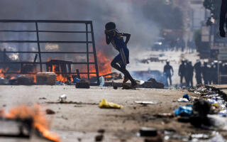 A boy runs past barricades as Senegalese demonstrators clash with riot police during a protest against the postponement of the Feb. 25 presidential election, in Dakar, Senegal February 4, 2024. REUTERS/Zohra Bensemra TPX IMAGES OF THE DAY
