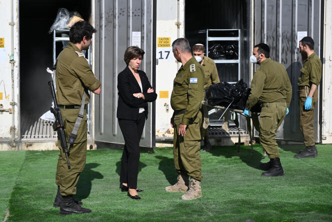 Catherine Colonna, alors ministre des affaires étrangères, se tient devant un conteneur de fret réfrigéré transformé en entrepôt de fortune pour les corps des victimes tuées lors de l’attaque du Hamas le 7 octobre 2023, à la base militaire de Shura près de Ramle, dans le district central d’Israël, le 17 décembre 2023.