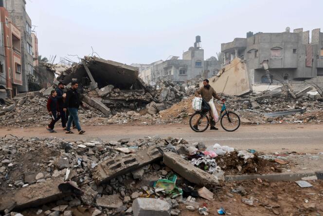 Des hommes marchent dans une rue ravagée par les bombardements israéliens à Rafah, dans le sud de la bande de Gaza, le 9 février 2024.