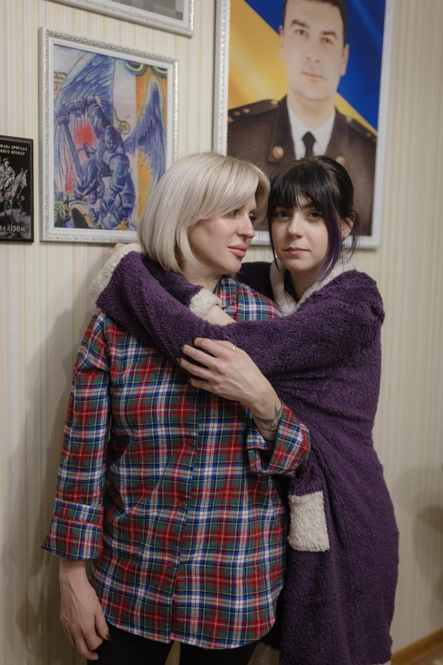 Iryna Bondarenko, 41, and her daughter Dasha, 19, at home. The portrait of Volodymyr, the deceased husband, hangs on the wall. Odesa, Ukraine, February 2, 2024.