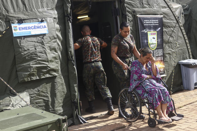 A woman suspected of having dengue fever is helped by soldiers at a military clinic set up to treat the epidemic, in Ceilandia, Brazil, February 9, 2024. 