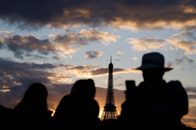Des touristes prennent une photo de la Tour Eiffel, à Paris, le 12 février 2024.