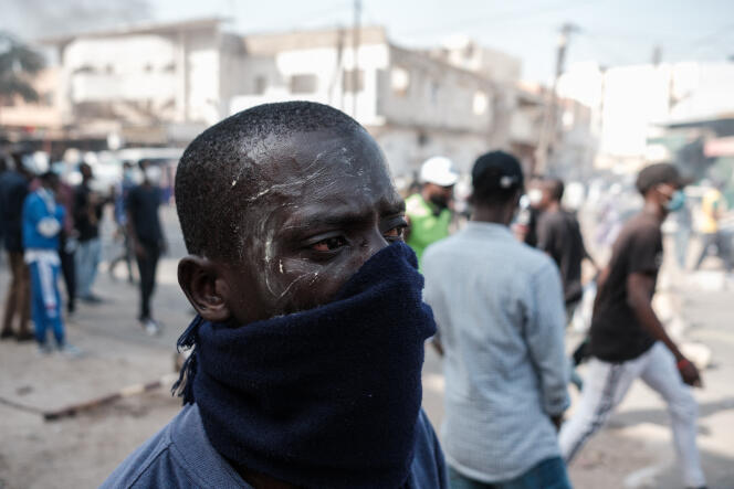 Un manifestante se protege de los gases lacrimógenos durante los enfrentamientos con la policía, en Dakar, el 9 de febrero de 2024.