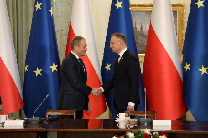 Polski premier Donald Tusk (po lewej) i prezydent Andrzej Duda podają sobie dłonie podczas spotkania 13 lutego. 