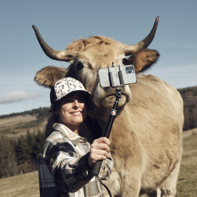 Pauline Garcia, éleveuse dans le Cantal, se photographie avec une de ses vaches, le 14 février 2024.