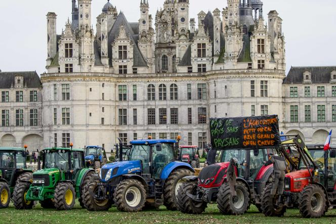 Des tracteurs portant des banderoles « Pas de pays sans paysans » et « L’agriculture, petit on en rêve, grand on en crève » sont garés devant le château de Chambord, dans le Loir-et-Cher, le 15 février 2024.