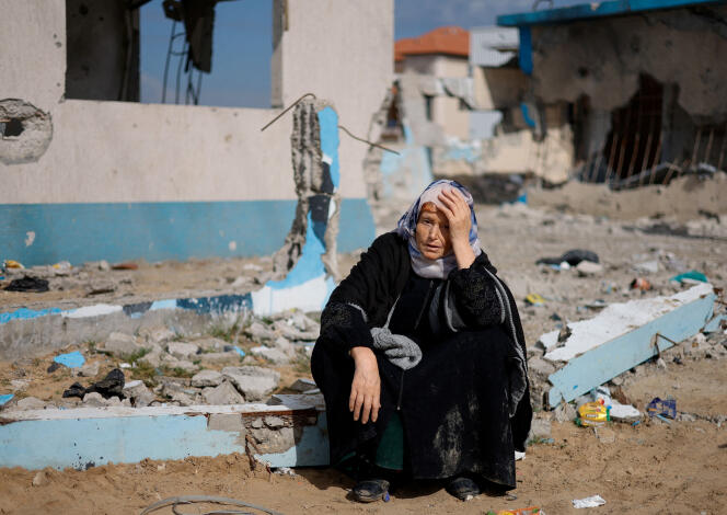 Una mujer descansa junto a un edificio dañado, mientras los palestinos llegan a Rafah después de ser evacuados del Hospital Nasser en Khan Yunis, el 15 de febrero de 2024.