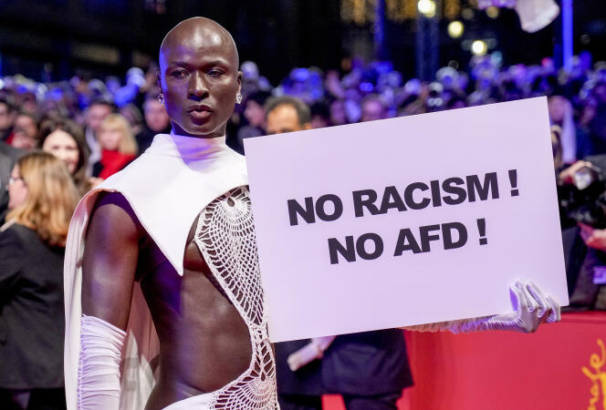 La modelo senegalesa Papis Loveday sostiene un cartel con la inscripción “¡No al racismo!”  ¡Sin AfD!  », en la alfombra roja frente al Berlinale Palast durante la inauguración de la 74ª edición de la Berlinale, en Berlín, el 15 de febrero de 2024.