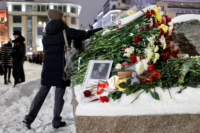 La policía de Moscú hace guardia frente al monumento dedicado a las víctimas de la represión soviética, mientras los transeúntes vienen a rendir homenaje a Alexeï Navalny, en Moscú, el 16 de febrero de 2024. 