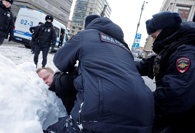 Un homme interpellé par la police près du monument à la mémoire des victimes des répressions politiques soviétiques, à Moscou, le 17 février 2024.