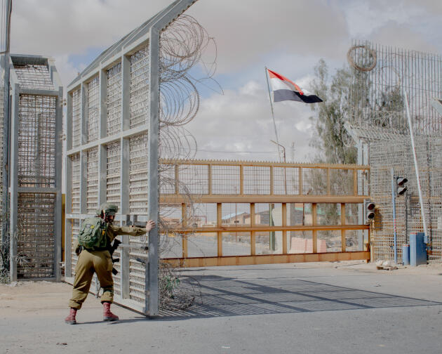 An Israeli soldier closes the barrier at the Nitzana border crossing between Israel and Egypt, following a gathering of protesters on February 18, 2024.