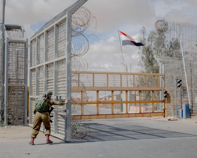 An Israeli soldier closes the barrier at the Nitzana border crossing between Israel and Egypt, following a gathering of protesters on February 18, 2024.