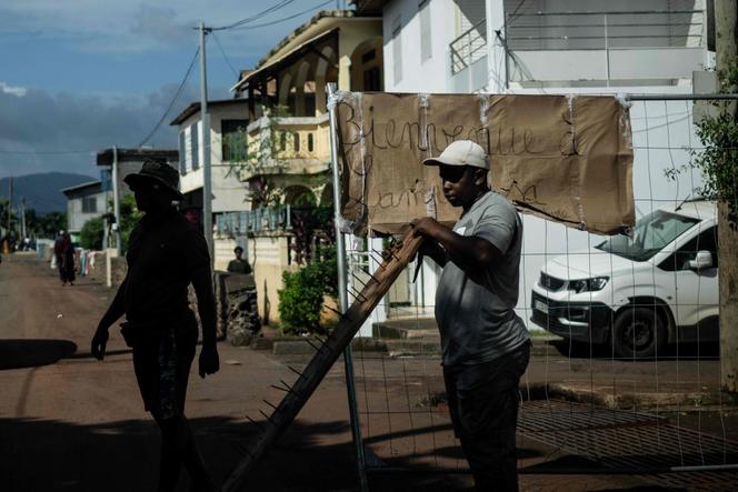 Un membre du collectif Forces Vives se tient sur un barrage routier, à Passamainty, le 15 février 2024, pour protester contre les conditions de vie et l’insécurité à Mayotte.