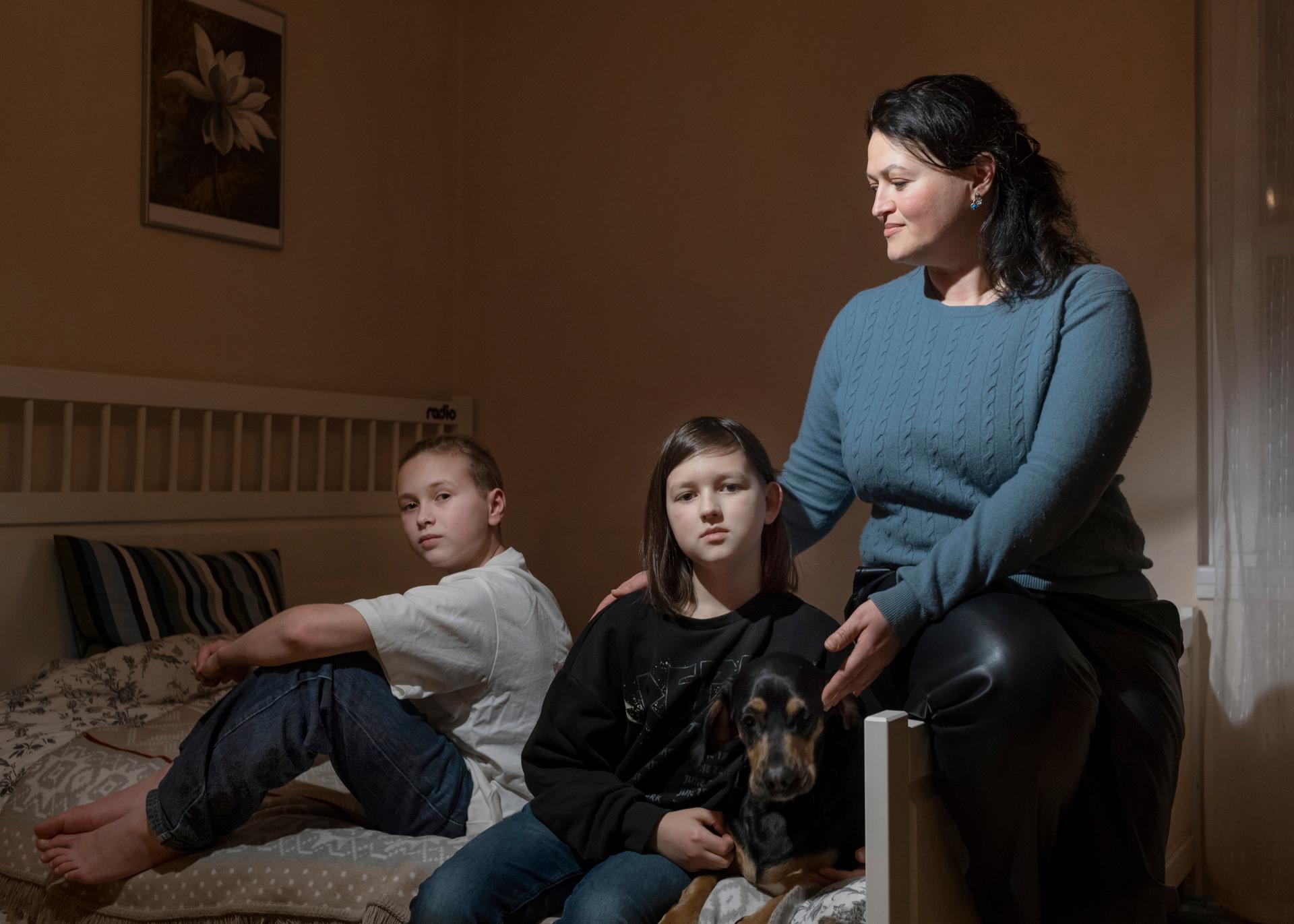 Iryna Kravchenko, 40 ans, et ses fils Yaroslav, 12 ans (à gauche), et Timur, 10 ans (au centre), ont fui la guerre en Ukraine pour se réfugier en Allemagne, dans leur nouvelle maison à Berlin, le 13 février 2024.