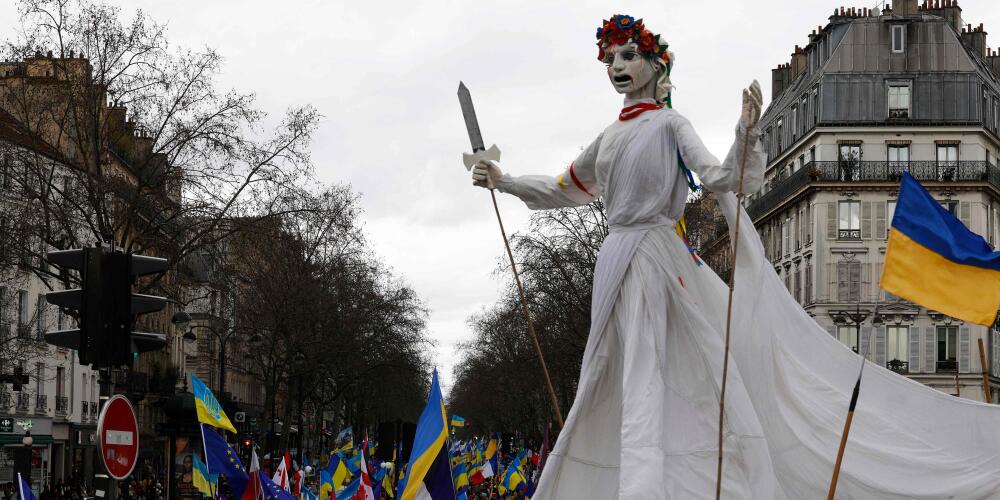Des manifestants portent une marionnette géante d’une jeune fille ukrainienne vêtue de blanc lors d’un rassemblement pour l’Ukraine à l’occasion du deuxième anniversaire de la guerre, place de la République, à Paris, le 24 février 2024.