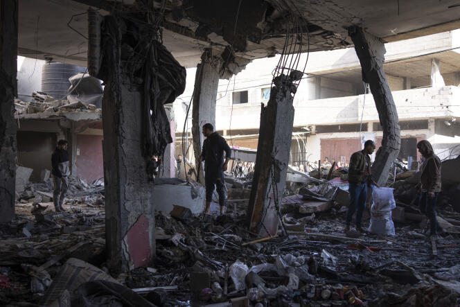 Palestinos en las ruinas de un edificio dañado por un bombardeo israelí en Rafah, 24 de febrero de 2024.