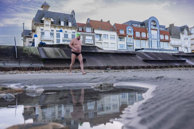 Stève Stievenart, 46 ans, nageur d’endurance en eau libre, marche sur la plage pour commencer un entraînement matinal dans l’eau de mer à Wimereux (Pas-de-Calais), le 26 janvier 2024.