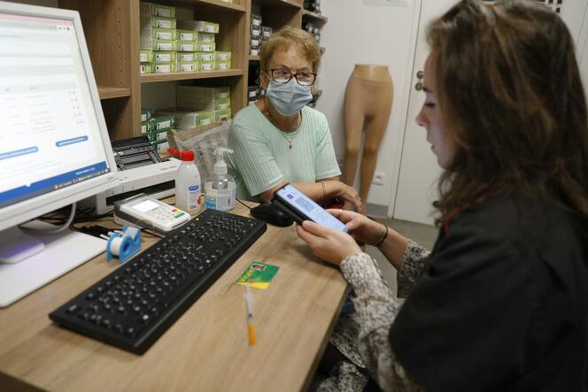 Une femme parle à une employée de la pharmacie avant de recevoir une dose de vaccin contre le Covid-19, à Ajaccio, le 5 octobre 2023.