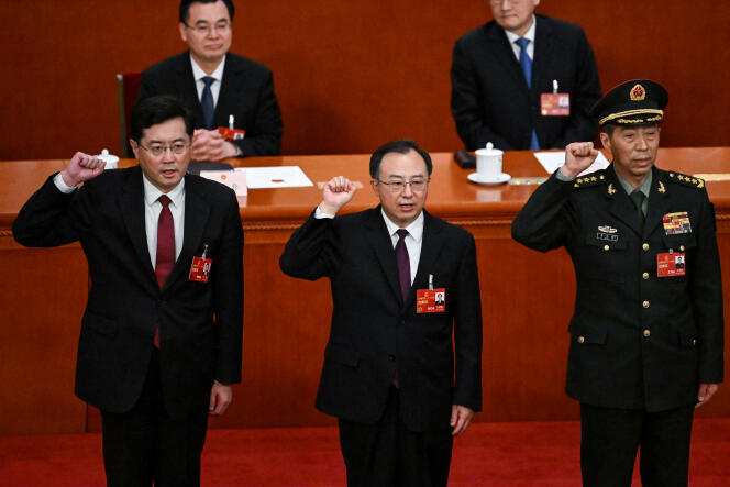 Qin Gang y Li Shangfu rodean a Wu Zhenglong, Consejero de Estado y Secretario General del Consejo de Estado, durante su juramento tras ser elegido durante la quinta sesión plenaria del Congreso Nacional del Pueblo, en Beijing, el 12 de marzo de 2023. 